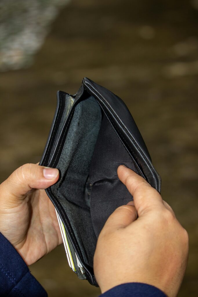 pexels-photo-8719576-8719576 A close-up image of an empty leather wallet held by two hands, symbolizing financial challenges.